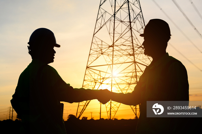 The silhouette of an electrical engineer with a worker Talk to each other and shake hands to agree o