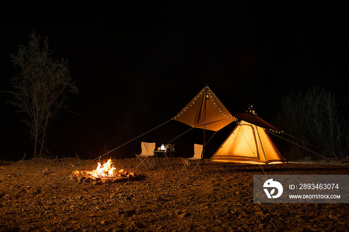 夜幕下的露营帐篷和篝火