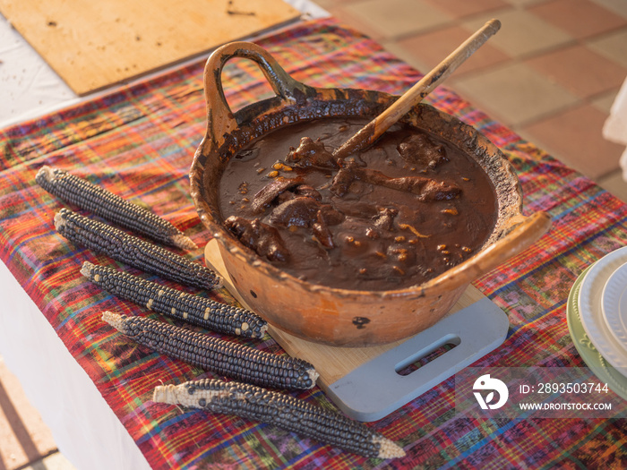 餐桌上放着鼹鼠和干玉米棒的粘土锅的俯视图