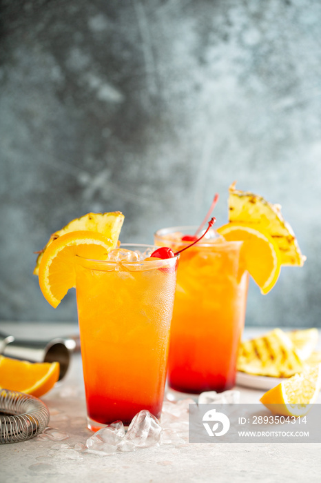 Tequila sunrise cocktail with grilled pineapple and orange