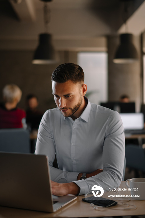 Portrait of handsome businessman in office.