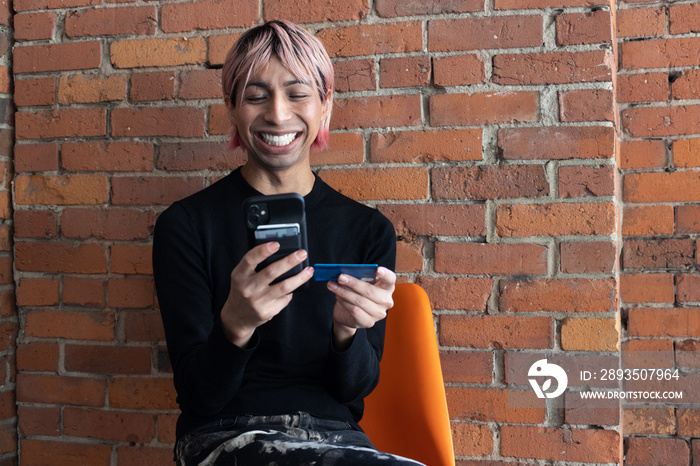 Non-binary person using their phone outside.