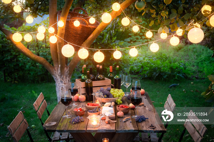 Rustic table with snacks and wine in the summer evening