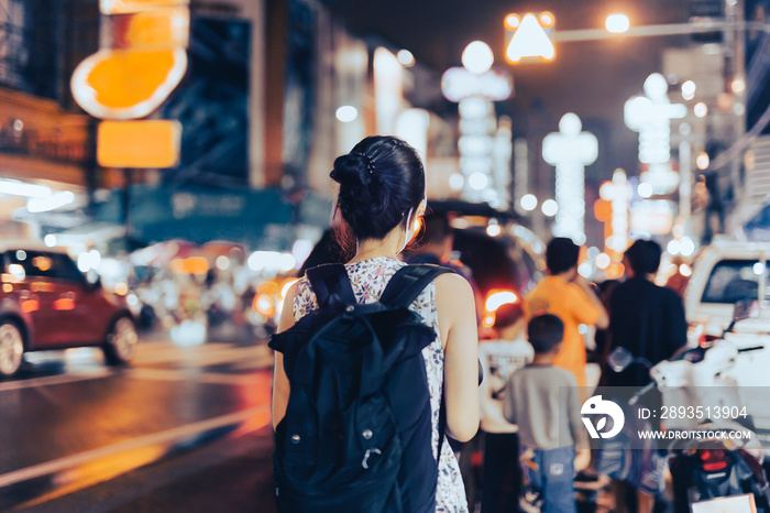 Asian woman traveler walking on street food night market in Chinatown.