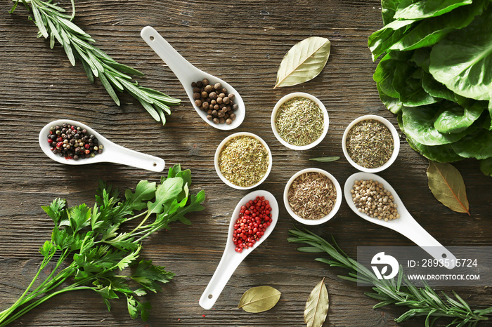 Different herbs and spices on wooden background