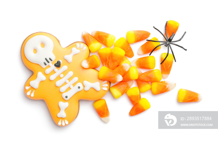 Tasty scary candies and cookie for Halloween on white background