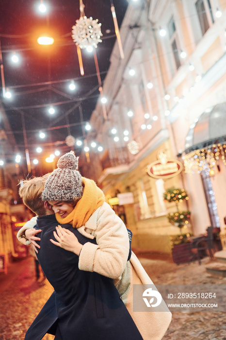 情侣们一起在圣诞装饰的街道上散步