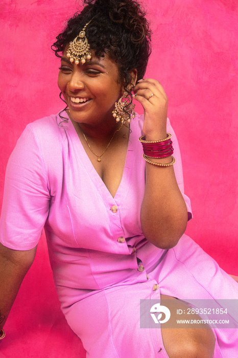 马来西亚-印度个人在粉色背景的摄影棚中笑着摆姿势