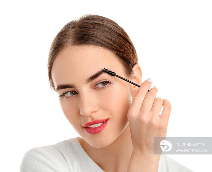 Young woman undergoing eyebrow correction procedure on white background