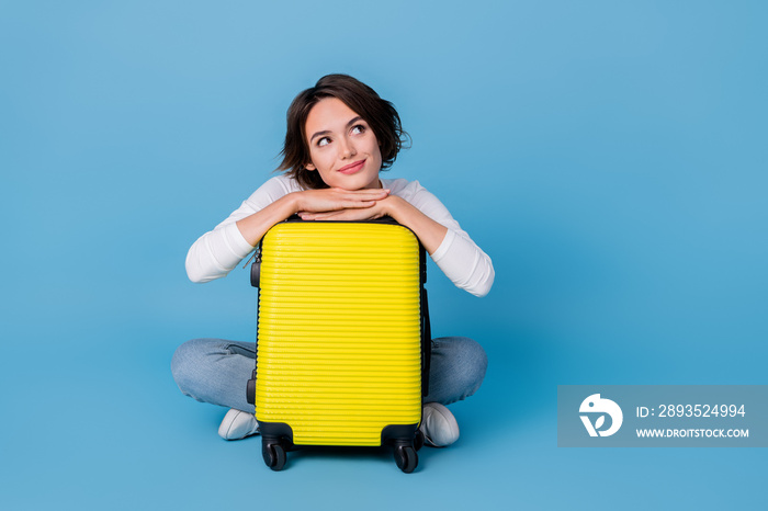 Photo of funny thoughtful woman wear white shirt hugging luggage looking empty space isolated blue c