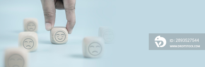 Hand holding wooden cube happy smile face, positive thinking, mental health assessment , world menta