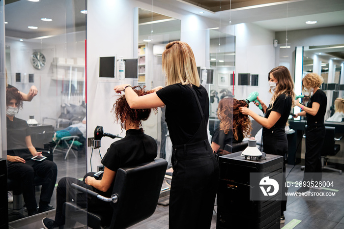 women in a beauty salon with social distance and protective masks