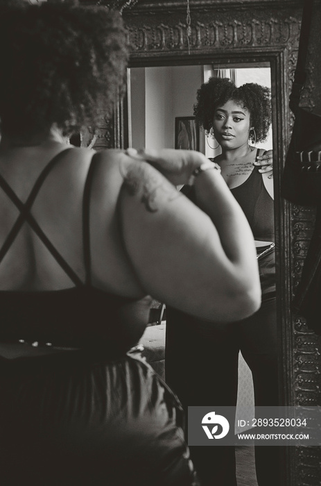 Black woman admiring herself in the mirror