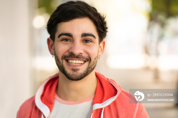 Close-up of young man smiling outdoors.