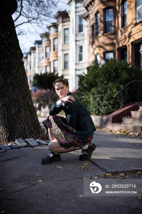 non-binary caucasian person with short hair posing on Brooklyn sidewalk