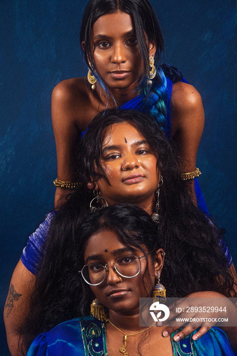 group portraits of dark skinned Indian women from Malaysia against a dark blue background