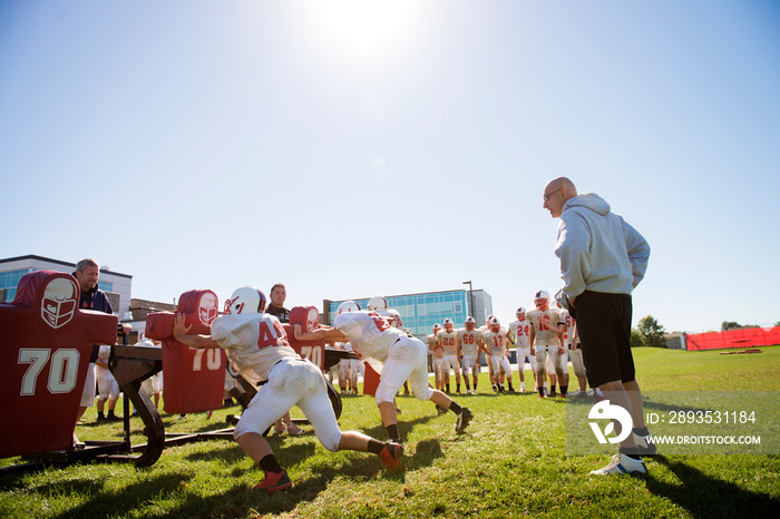 Teenage boys (14-15, 16-17) practicing american football