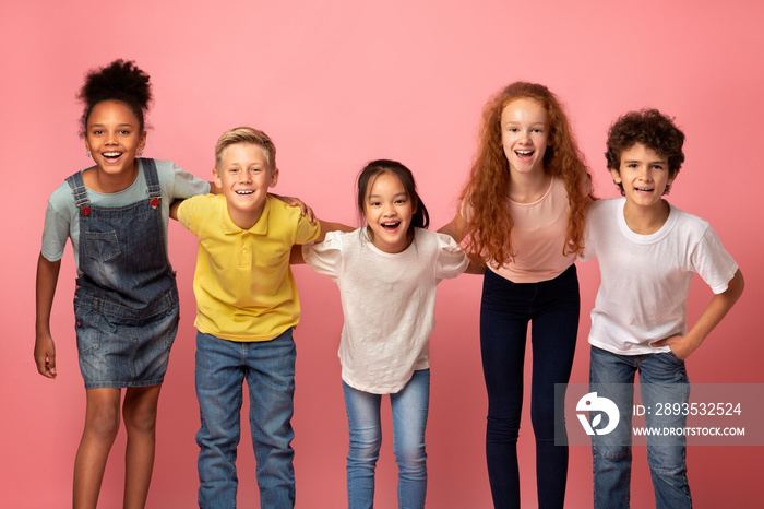 Portrait of multiethnic schoolkids smiling on pink background