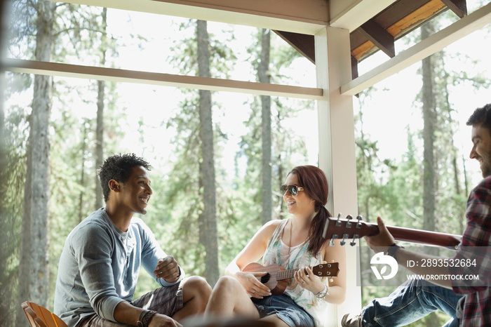 Friends playing music on cabin patio