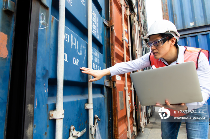 Import and export concept. Fore man shipper using tablet and computer laptop to monitor container an