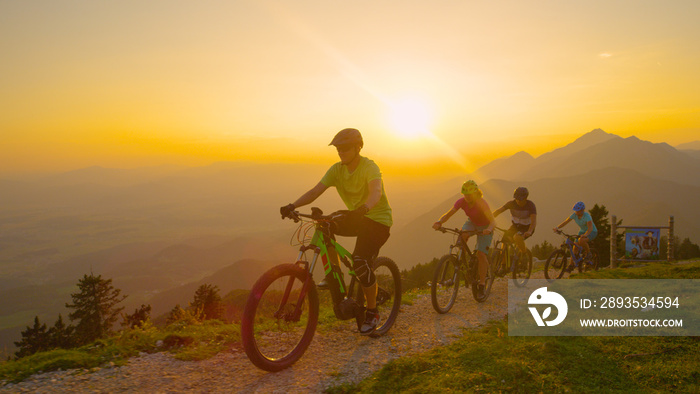 CLOSE UP: Group of friends enjoying scenic cross country bicycle ride at sunset.