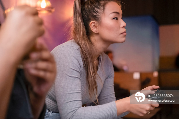 Friends playing in video games at pub