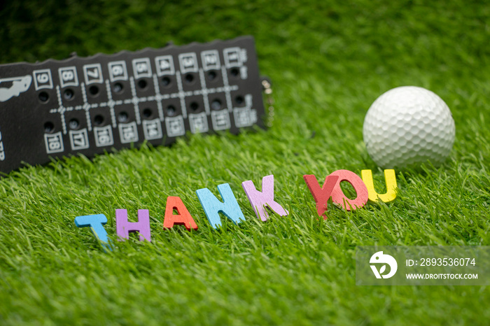 golf ball with thank you word on green grass