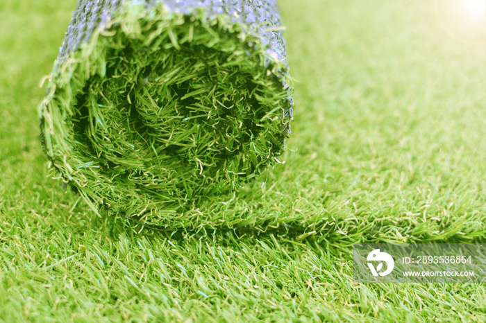Artificial turf roll. Synthetic grass lawn laying background.
