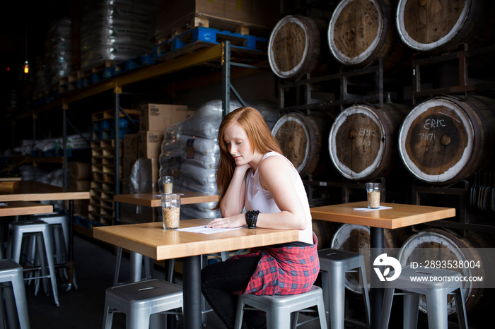 Young woman sitting in brewery