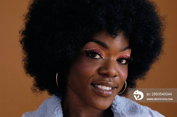 Studio portrait of young beautiful women with afro hair smiling