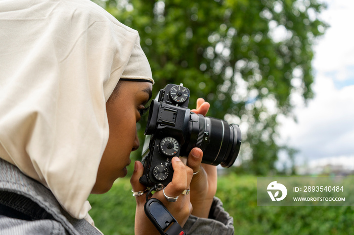 Close-up�of young woman wearing�hijab�photographing with digital camera