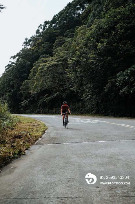 A young female cyclist riding her gravel bike in the mountains.