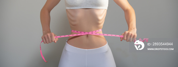 Weight loss, waist measurement, diet and health concept. Woman measuring her waist.