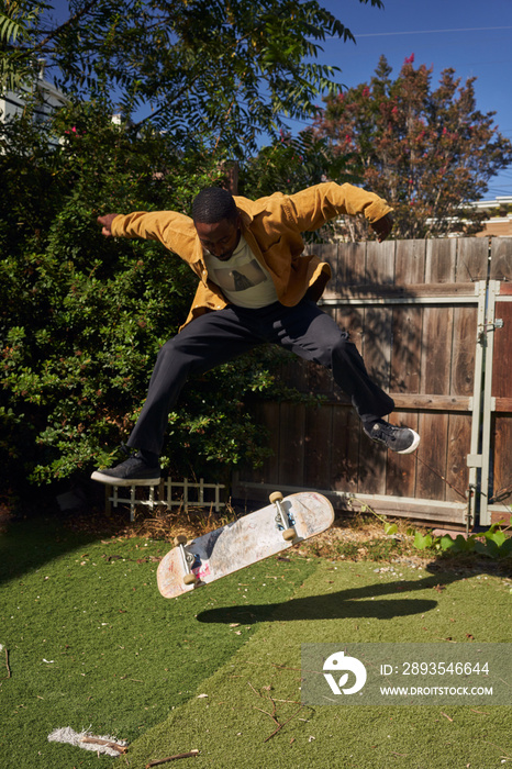 Portrait of young non-binary doing flip tricks on skateboard