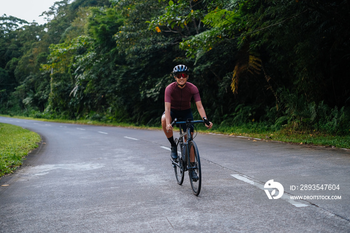 A young female cyclist riding her gravel bike in the mountains.