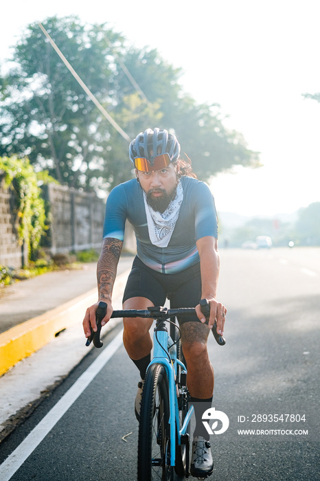 A bearded cyclist riding his gravel bike.