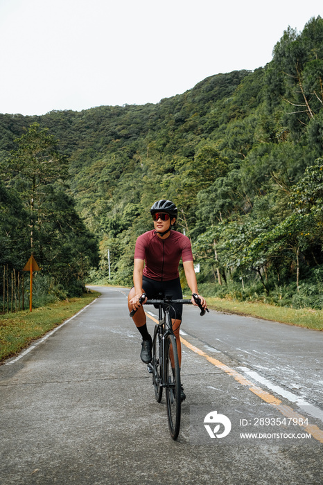 A young female cyclist riding her gravel bike in the mountains.