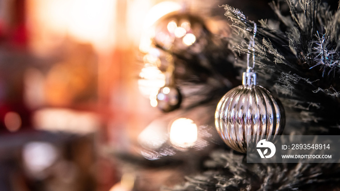 圣诞树树枝上的银色圣诞球，背景是红色的复制空间。装饰