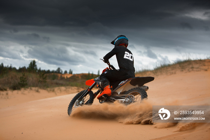 Motorcyclist on a cross-country motorcycle go fast at the desert