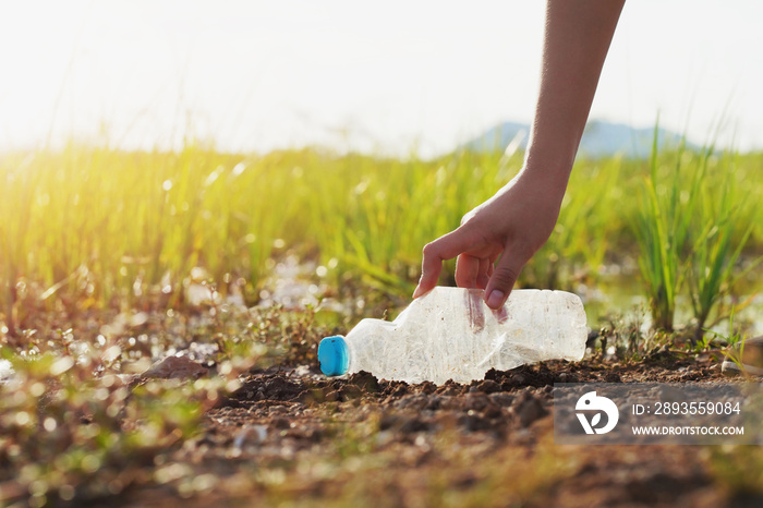 woman hand picking up garbage plastic for cleaning at river