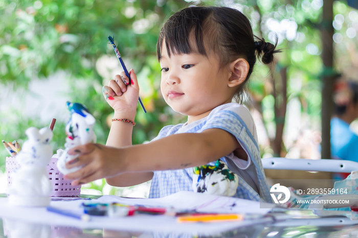 Selective focus. Portrait image of 2-3 yeas old child girl. Asian student drawing and painting colou