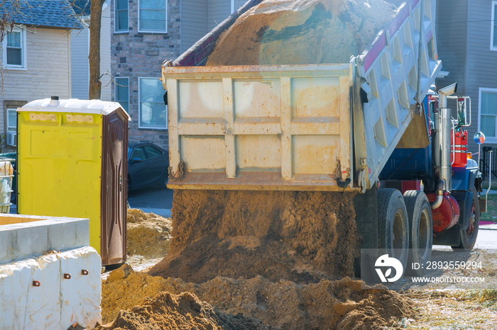 Truck pour soil on the ground in construction area.