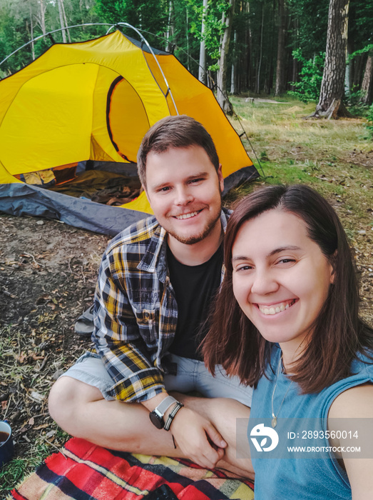 couple taking selfie picture sitting outdoors tent on background