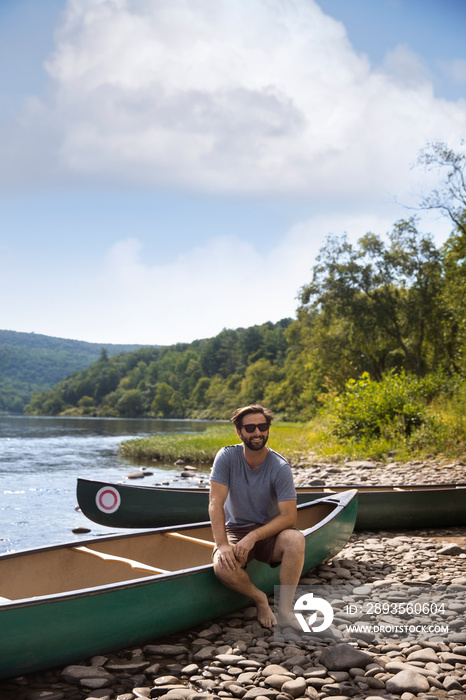 Man wearing sunglasses sitting on canoe