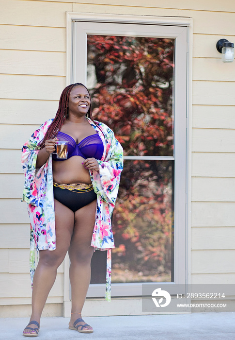 Black woman outside having tea with robe panty and bra on