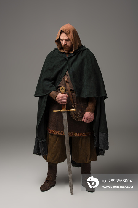 中世纪苏格兰红发骑士，披挂斗篷，灰色背景为剑