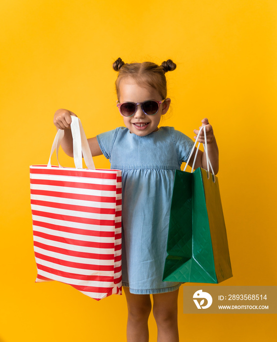 Portrait Beautiful Happy Little Preschool Girl In Sunglasses Smiling Cheerful Holding Cardboard Bags