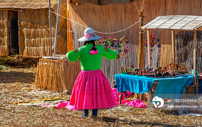 Indigenous art and craft saleswoman in flashy tribal colors on the Uros floating Islands with totora