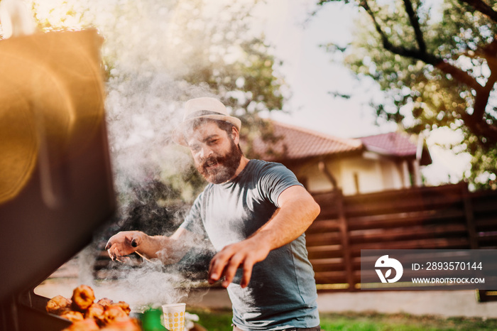 Portrait of man hand cooking barbeque and grilled meat barbecue party at backyard..