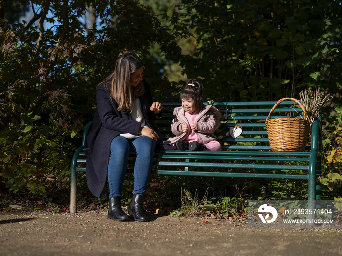 患有唐氏综合症的母亲和女儿坐在长椅上